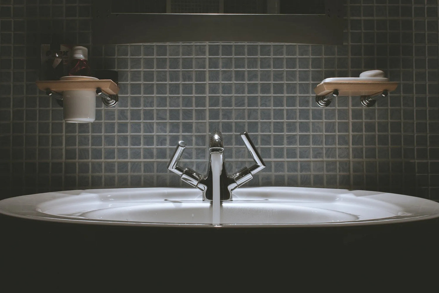 Chrome faucet above a tiled bathroom sink